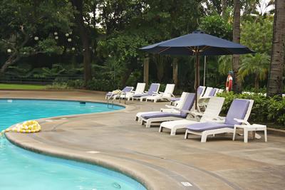 Picture of several lounge chairs and an umbrella on a stamped concrete pool deck